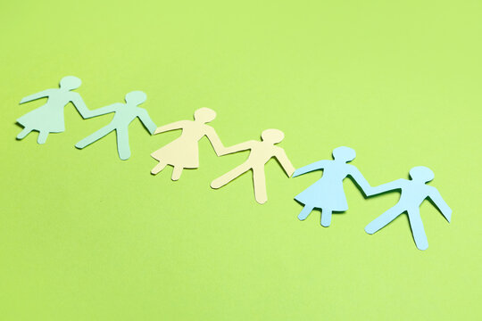 Paper human figures on green background