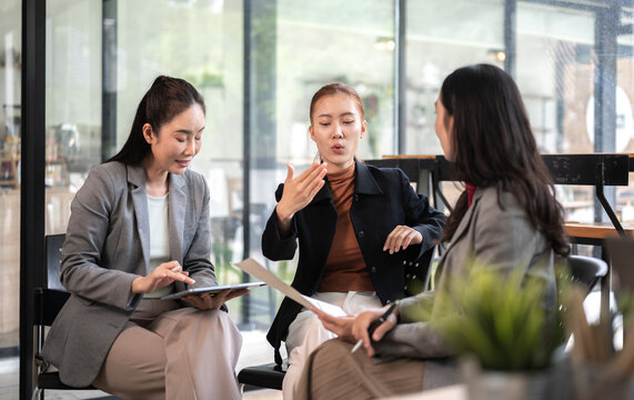 Business meeting with women discussing project plans and reviewing business reports