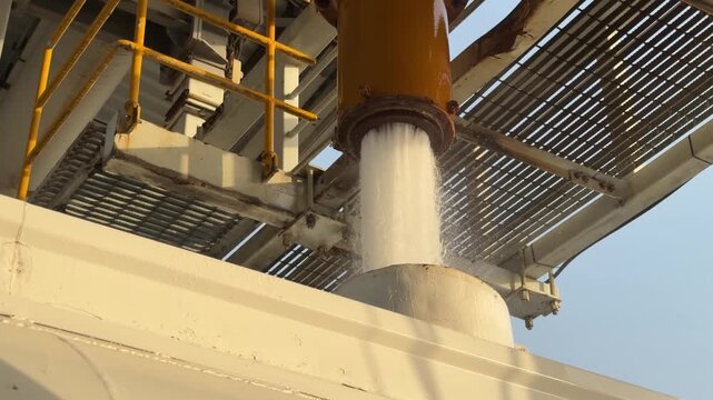 An industrial tanker fills from a high‑pressure overhead pipe at a refilling bay near EGA in Dubai&rsquo;s logistics zone.