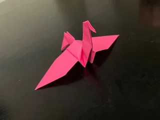 Fotobehang Kraanvogels Pink origami paper bird against a black background  © Visualroom