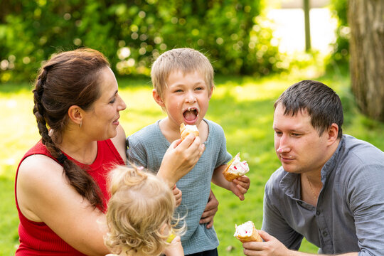 Mother Feeding Ice Cream to Son During Family Outing