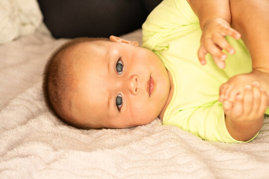 Calm Baby Boy Lies on Soft Bed at Home