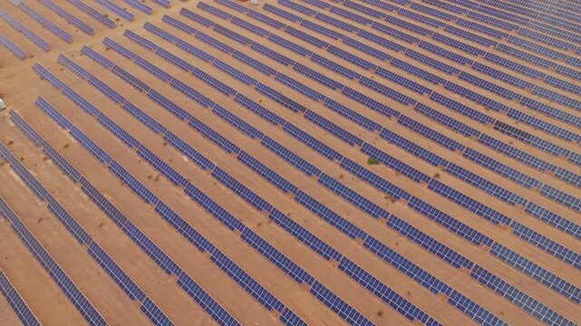 Solar photovoltaic panels at sunrise/sunset; wind turbine power plant; new energy