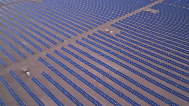 Solar photovoltaic panels at sunrise/sunset; wind turbine power plant; new energy