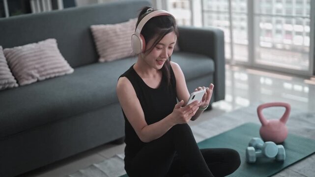 Asian fitness woman using phone for workout search online