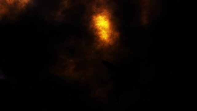 Silhouette of commercial airplane flying through dark stormy clouds at night.