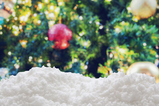 Empty white snow with blur Christmas tree with bokeh light background
