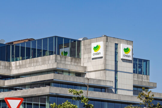 Antwerp, Belgium - 14 August 2026: Commercial office building displaying the logo of Crelan Bank against a clear blue sky background.