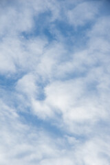 Fototapeta premium White fluffy clouds against a bright blue sky, creating a serene and tranquil atmosphere in a clear weather setting. Abstract cloud background, design element, for overlay on pictures