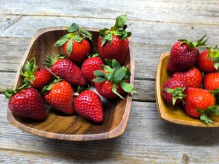 uicy ripe beautiful strawberries in a wooden plate on the table © nicolas