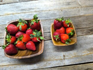 uicy ripe beautiful strawberries in a wooden plate on the table © nicolas