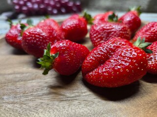Ripe sweet strawberries in a wooden plate on a wooden © nicolas