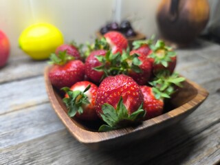 juicy ripe strawberries lie in a wooden plate © nicolas