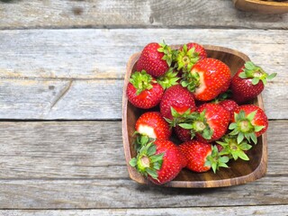 juicy ripe strawberries lie in a wooden plate © nicolas