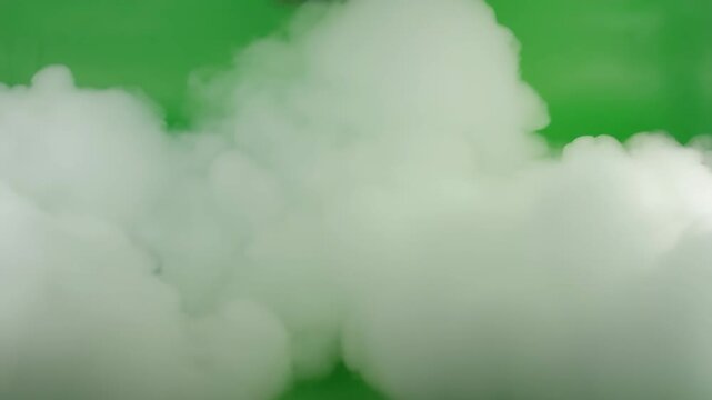 Dichte Rauchwolke und Nebel steigen im Studio vor gr&uuml;nem Chroma Key Greenscreen