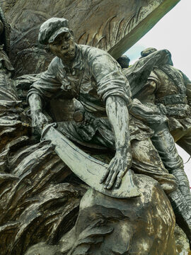 Bronze revolutionary soldier statue with machete in dramatic battle pose