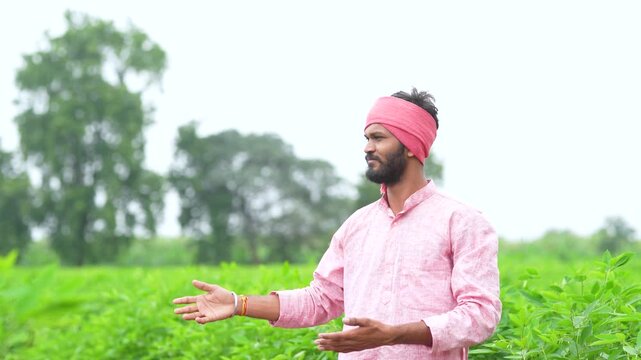 young indian farmer walking at pigeon pea agriculture field