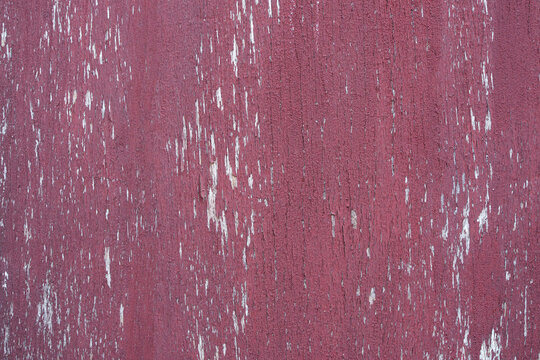 Rustic weathered red peeling paint on wooden surface texture background.