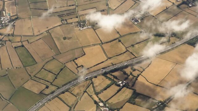 High Aerial Above M5 Motorway in England Surrounded by Browned Fields After Record Heatwaves Causing Prolonged Drought During Summer of 2026. Highlights Effect of Climate Change.