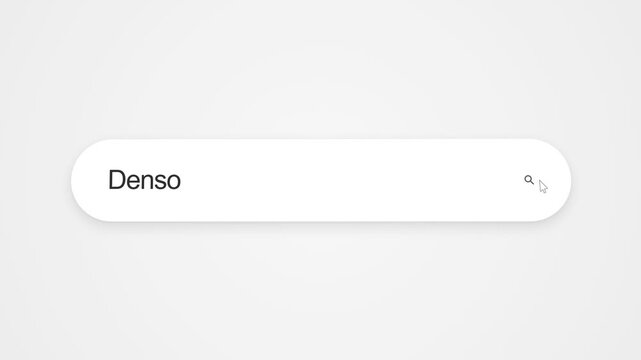 Typing Denso into an internet search bar on a computer screen, illustrating online search, automotive technology research and web browsing