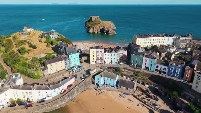 Tenby harbour and St Catherine Island in Pembrokeshire, Wales, showing colorful Georgian townhouses, pier wall and moored boats on calm water in summer