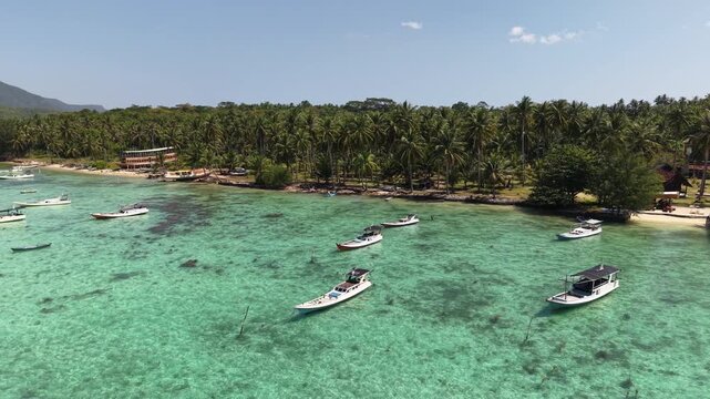 Aerial drone view of Barakuda Beach in Karimunjawa, Indonesia, showcasing white sand, turquoise water, tropical coastline, and lush coconut trees.