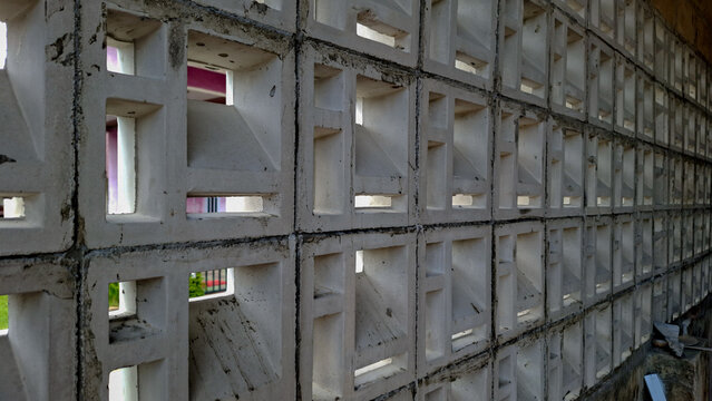 Geometric pattern of concrete ventilation breeze blocks. Modern architectural wall design offering air circulation, shade, and decorative structure.