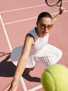Female Tennis Player Serving Ball on Outdoor Court