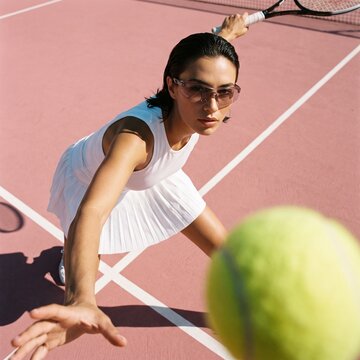 Female Tennis Player Serving Ball on Outdoor Court