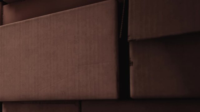 People use cardboard boxes for storage. Boxes are stacked on top of each other, creating a solid arrangement. This scene is in an indoor space with good light.