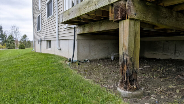Rotted post base beneath a wooden deck