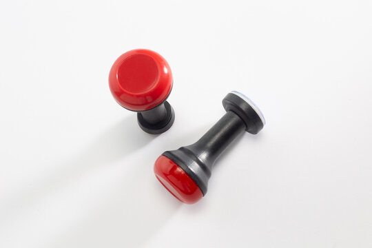 Two red and black rubber stamp tools isolated on white background top view