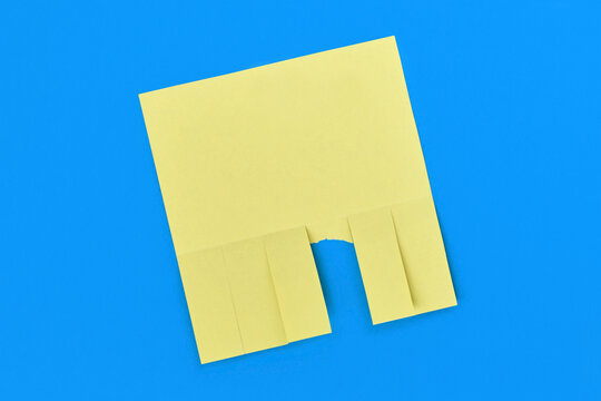 Yellow tear off flyer with multiple detachable tabs and one strip torn away on blue background. Blank notice template for advertisements or contact tear off notes