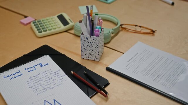 Office desk displaying employment contract, calculator, and handwritten financial notes from high angle view. Footage is perfect for human resources and corporate onboarding campaigns