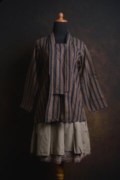 Traditional Indonesian Kebaya with Lurik Pattern or vertical pattern with brown layered skirt on a display mannequin