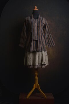 Traditional Indonesian Kebaya with Lurik Pattern or vertical pattern with brown skirt on a display mannequin