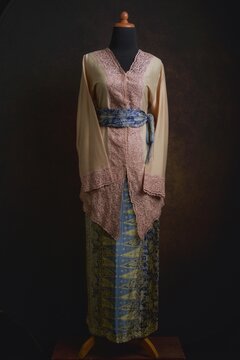 Indonesian Kebaya with Embroidered Lace Accent and Batik Skirt and Belt Displayed on A Dress Form