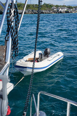 Inflatable dinghy tender floating next to a sailing yacht © Irina