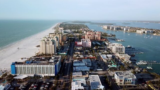 Aerial drone footage of Clearwater Beach coastal city skyline and white sand shore.