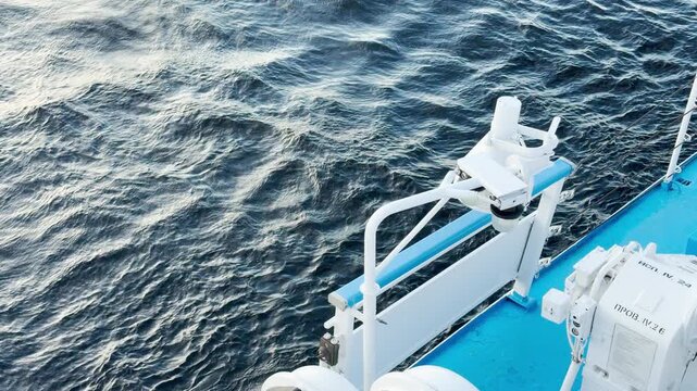 A cruise ship deck sails over the rippling dark waters of Lake Ladoga. The bright blue structure contrasts with the deep waves. This quiet voyage brings a feeling of calm and peaceful relaxation.