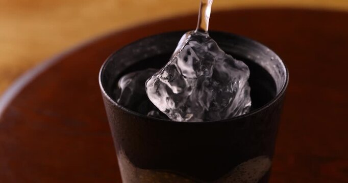 氷の入ったグラスに焼酎を注ぐ