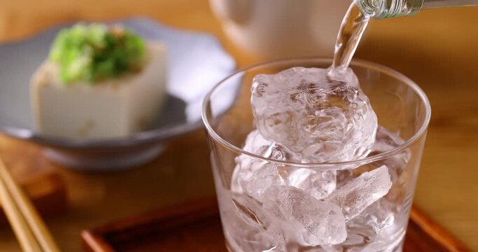 氷の入ったグラスに焼酎を注ぐ