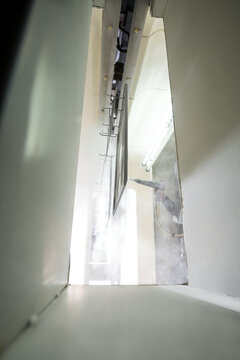 Industrial spray painting inside metal enclosure with mist and bright lighting