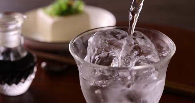 氷の入ったグラスに焼酎を注ぐ