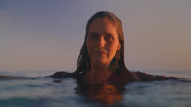 A calm portrait shows a woman floating at the water's surface from a different angle.