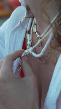 Jewelry styling session focusing on beaded seashell necklaces with starfish charms against a white shirt. Macro close-up shot.