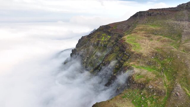Aerial view of a rugged mountain landscape with a cloud inversion in the east of Iceland