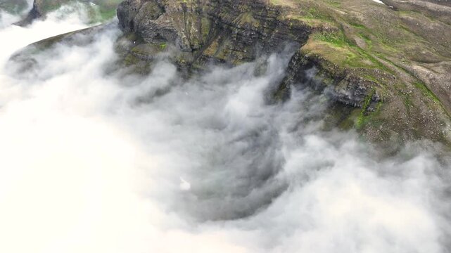 Aerial view of a rugged mountain landscape with a cloud inversion in the east of Iceland