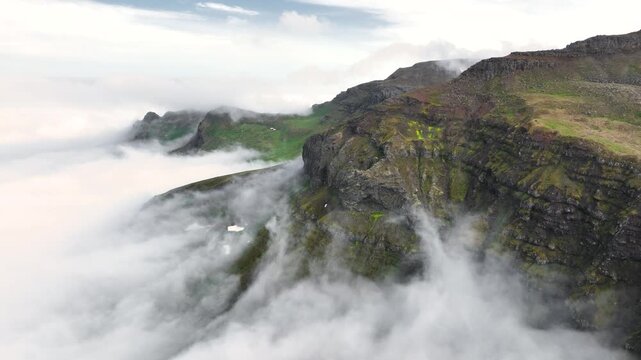 Aerial view of a rugged mountain landscape with a cloud inversion in the east of Iceland