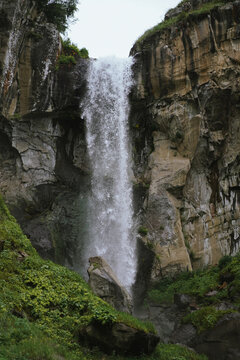 Powerful waterfall crashing down a rocky mountain cliff